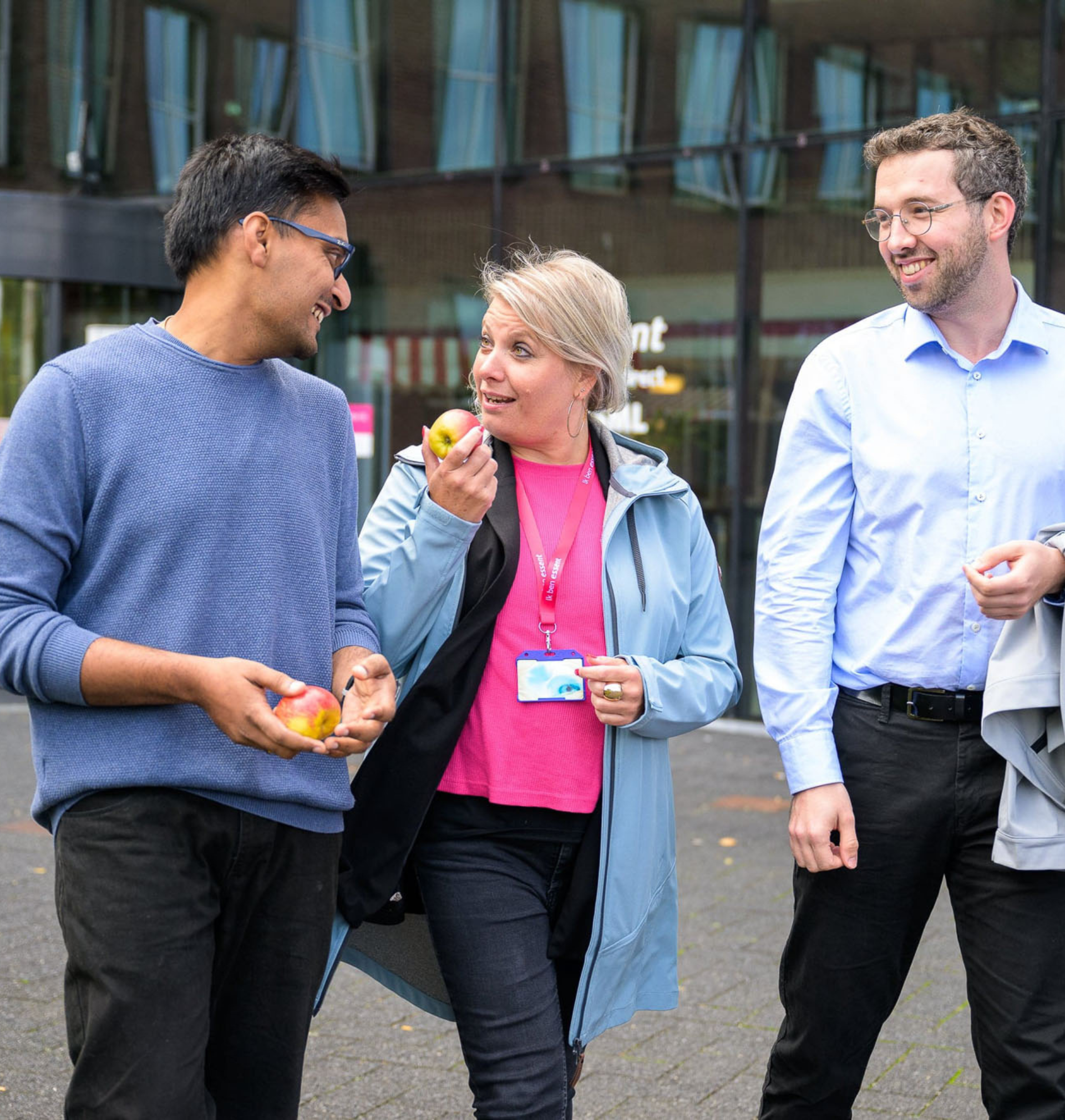 Drie medewerkers van Essent die een rondje gaan wandelen terwijl ze een appel eten