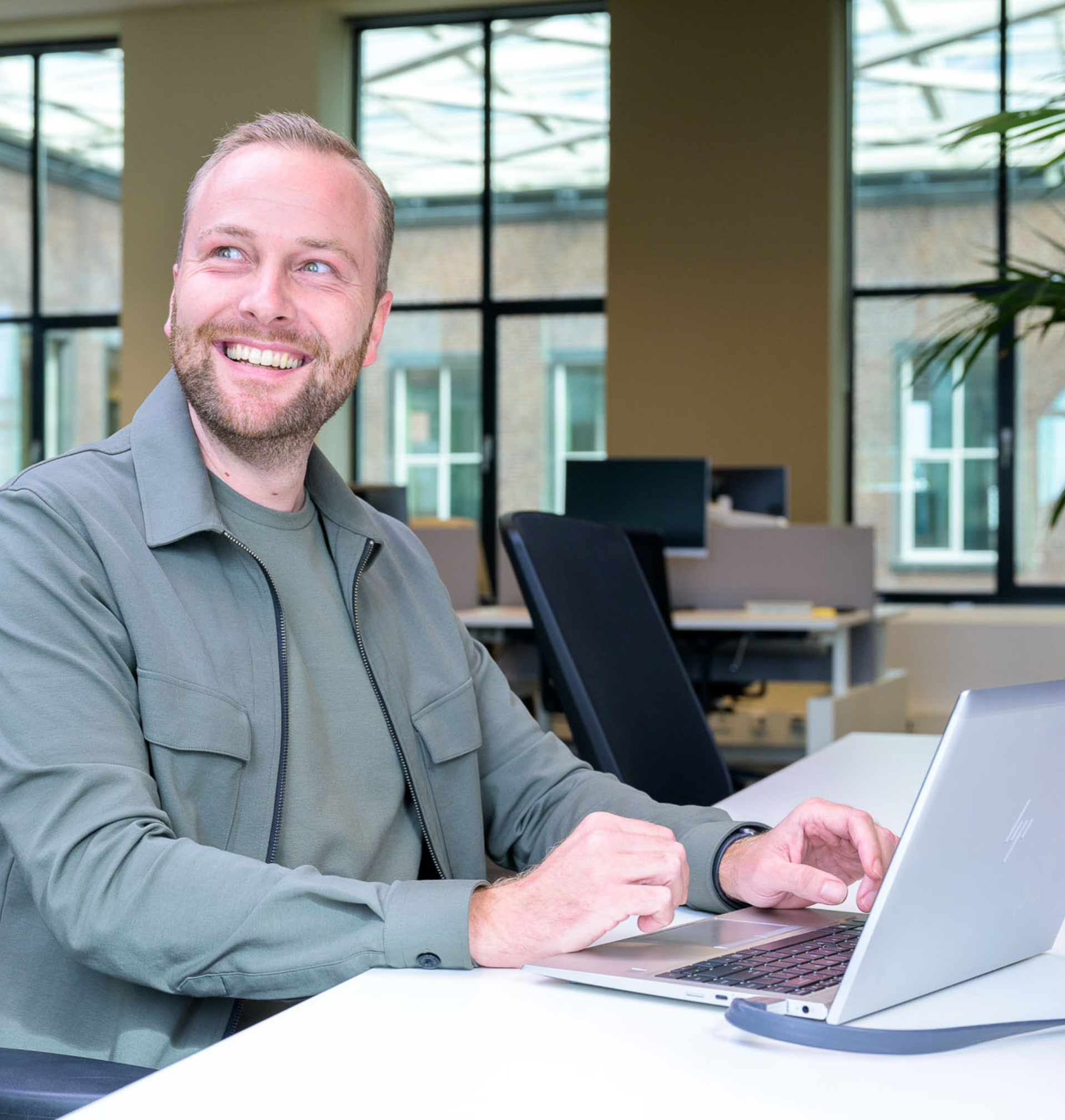 Essent recruiter lachend achter laptop