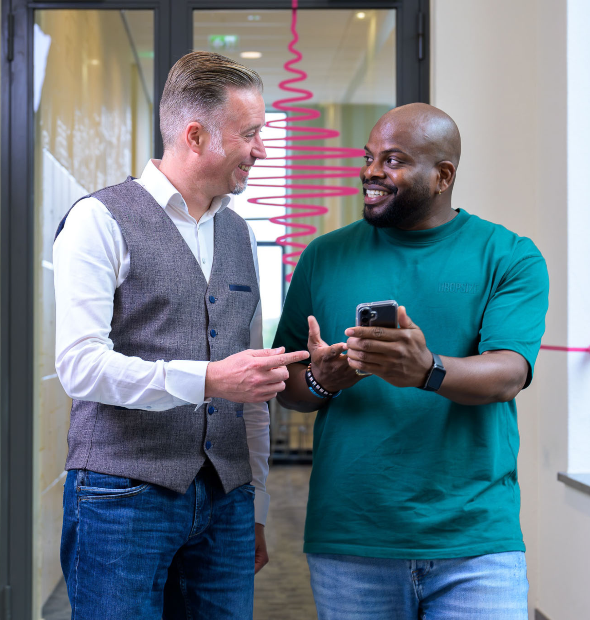 Twee mensen pratend en wijzend naar een telefoon