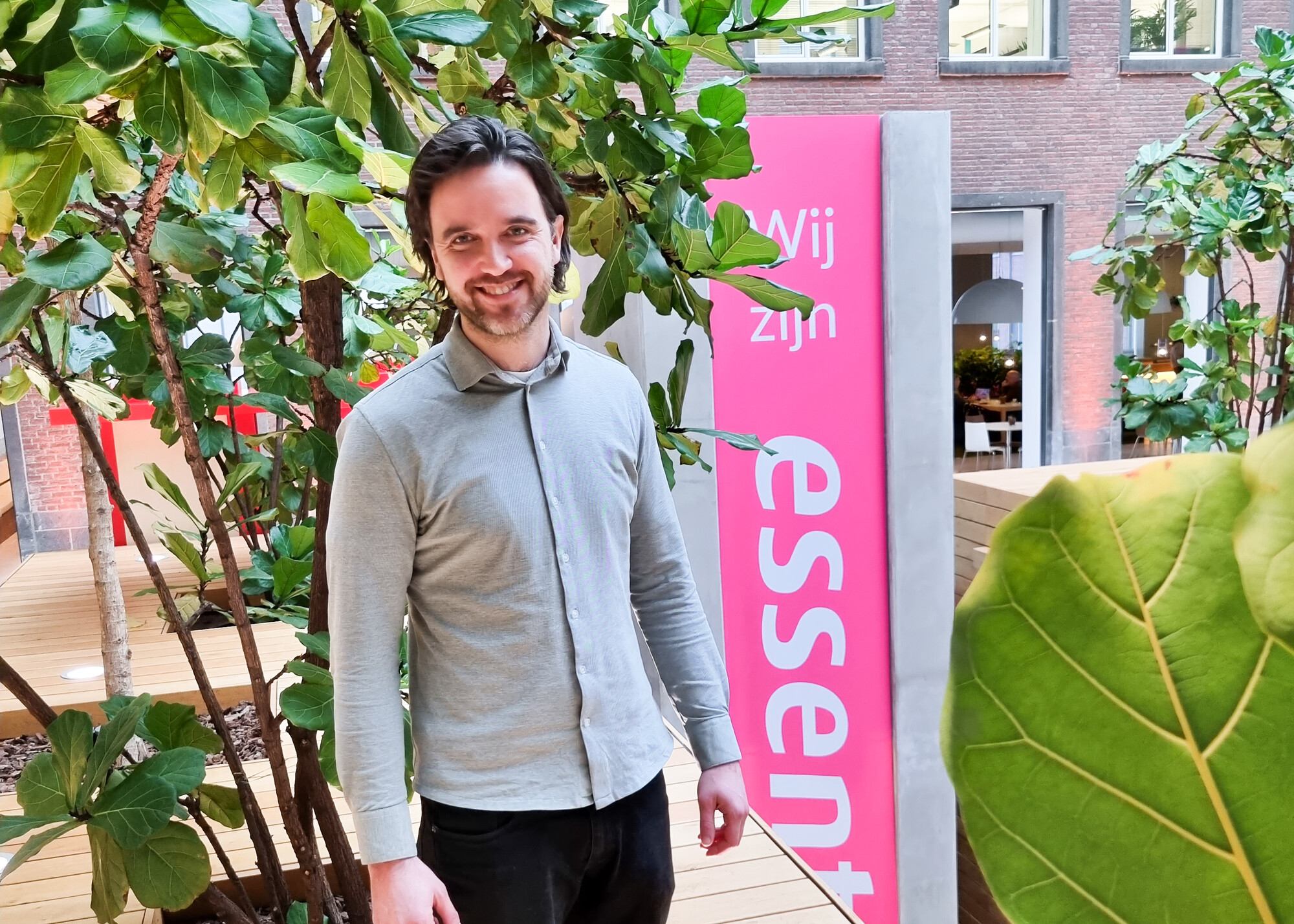 Man staat voor Essent bord en plant