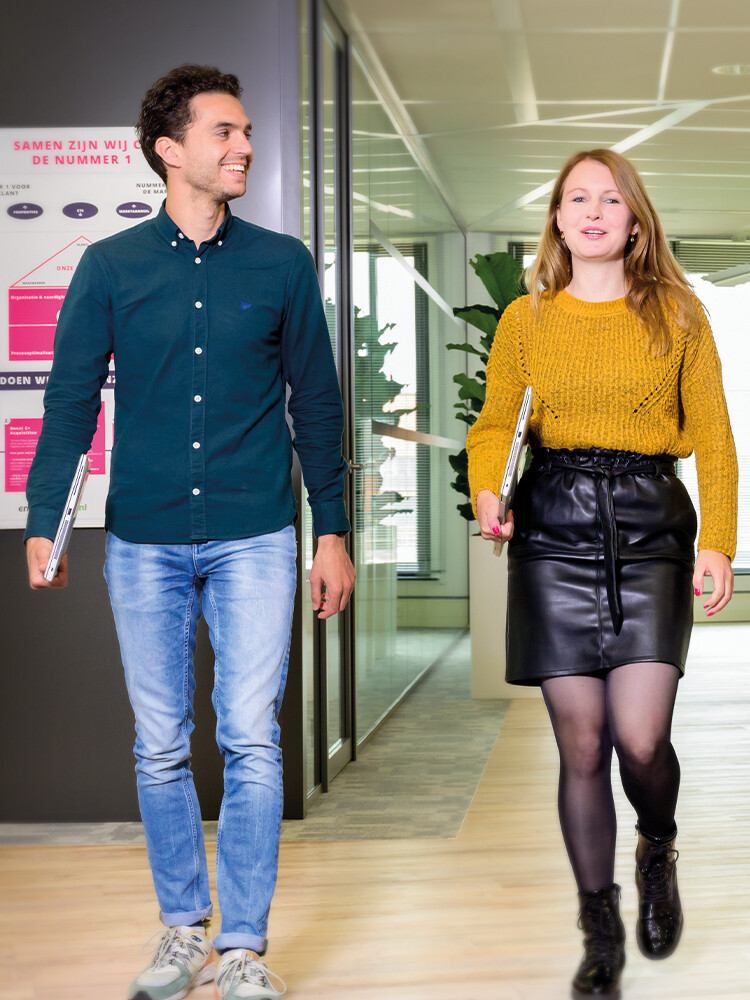 Twee mensen lopend door een kantoorruimte