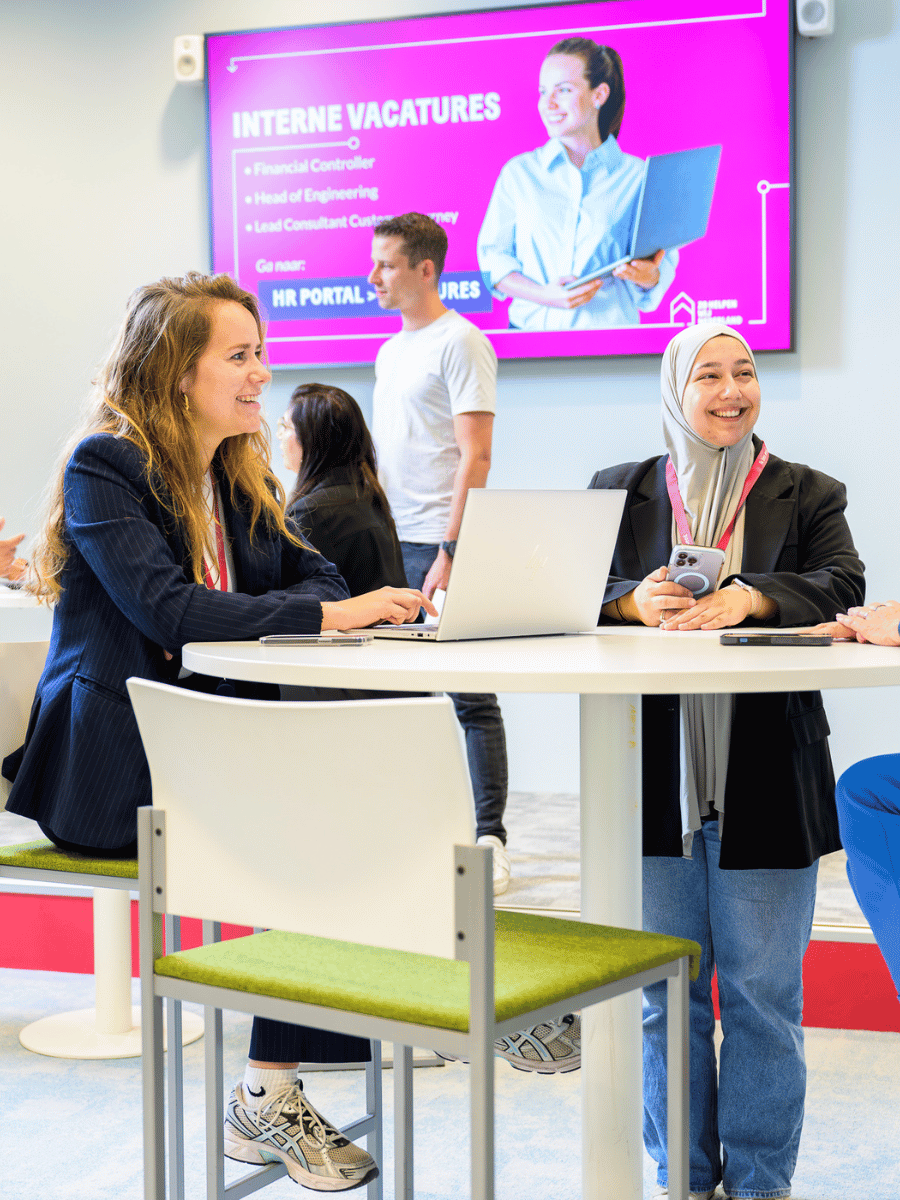 Collega's aan hoge tafel lachend 