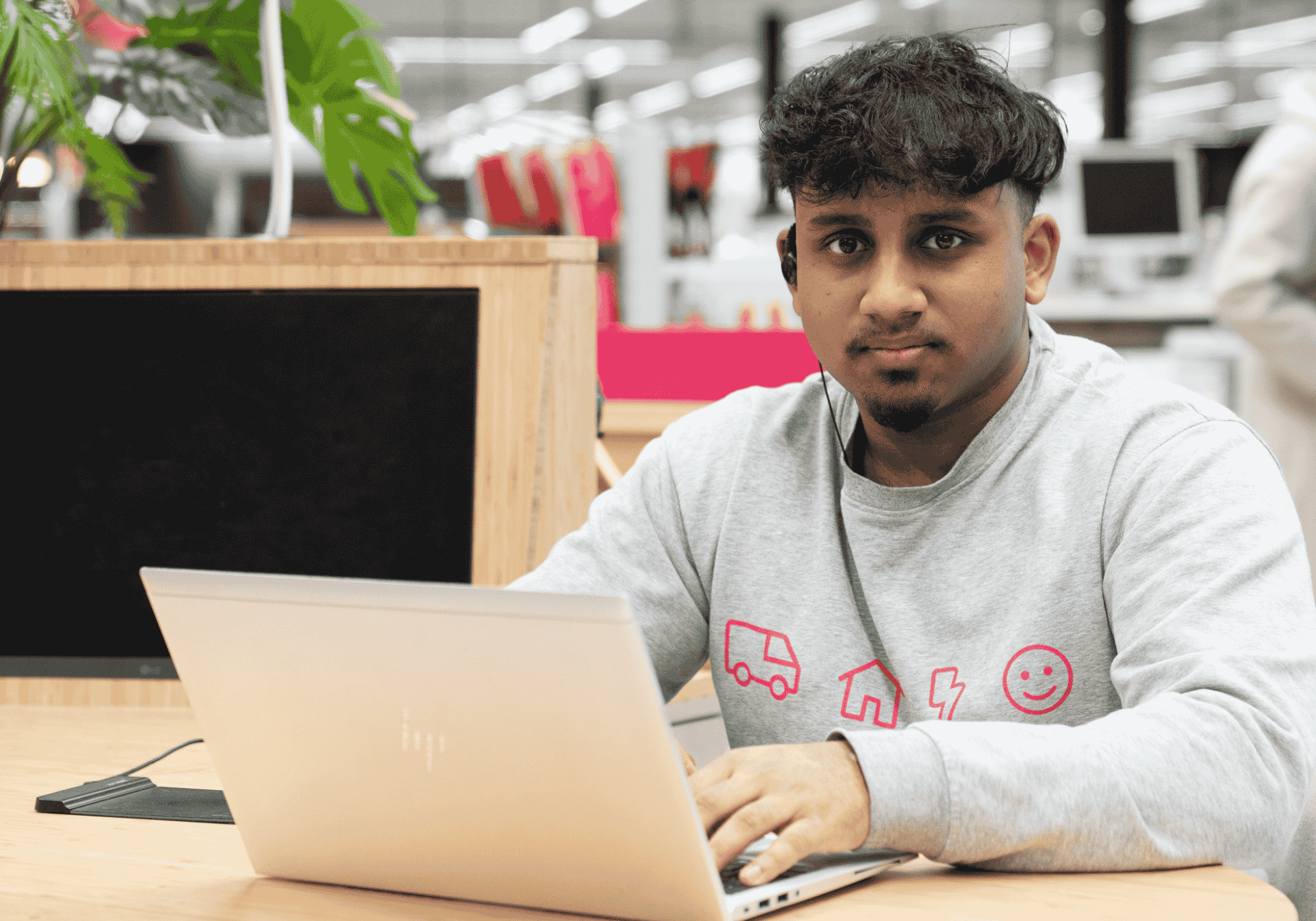 Collega zittend achter laptop in shop-in-shop in de Media Markt