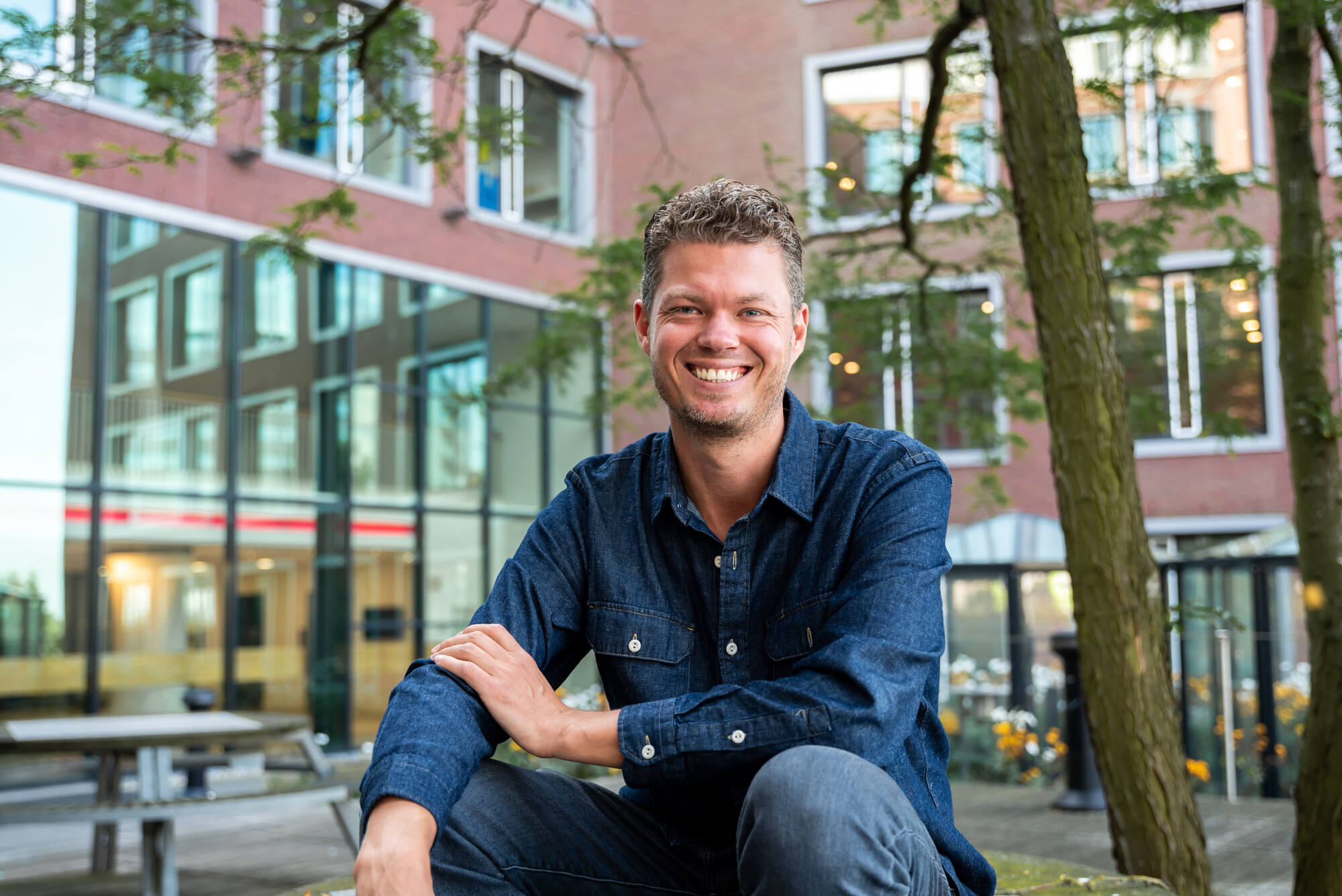 Lachende man zittend op picknick tafel