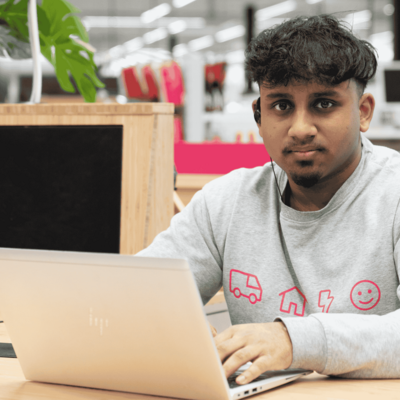 Collega zittend achter laptop in shop-in-shop in de Media Markt