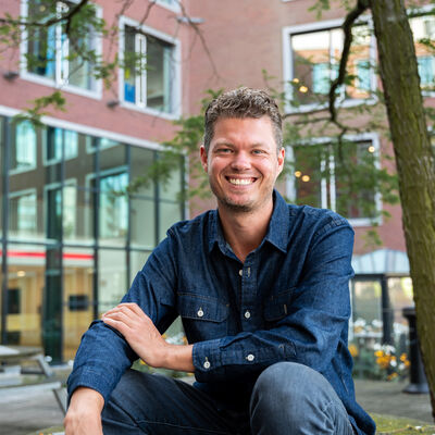 Lachende man zittend op picknick tafel